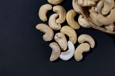 Cashew nuts in basket on black backgroundの写真素材