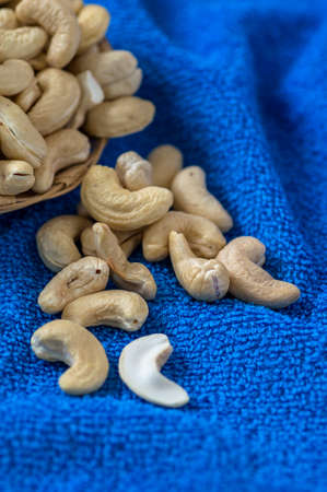 Cashew nuts in basket on blue backgroundの写真素材