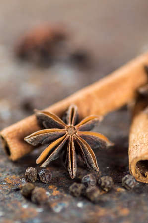 Cinnamon sticks, anise stars and black peppercorns on textured backgroundの写真素材