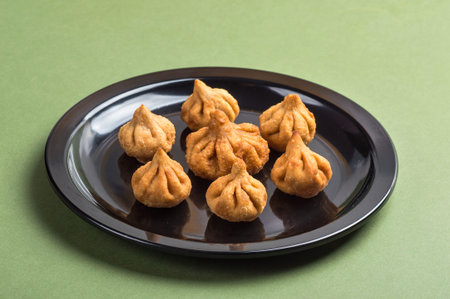 Indian Food: Modak on green background, Maharashtra Sweet Dish, favourite sweet of lord ganesha,...