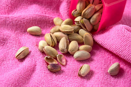 Pistachios in container on pink backgroundの写真素材