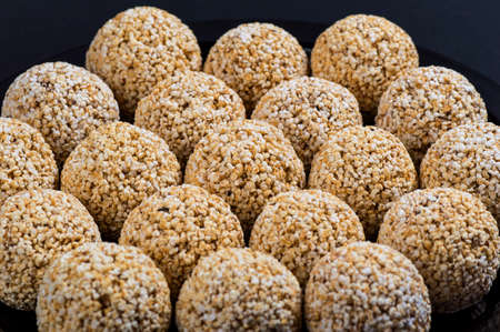 Amaranth ladoo or Rajgira laddu or Cholai ke laddo in black plate on black background.の写真素材