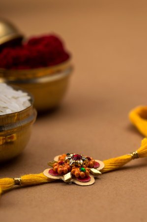 Raksha Bandhan background with an elegant Rakhi, Rice Grains and Kumkum. A traditional Indian wrist...