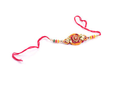 Indian festival: Raksha Bandhan background with an elegant Rakhi on a white background. A traditional Indian wrist band which is a symbol of love between Brothers and Sistersの写真素材