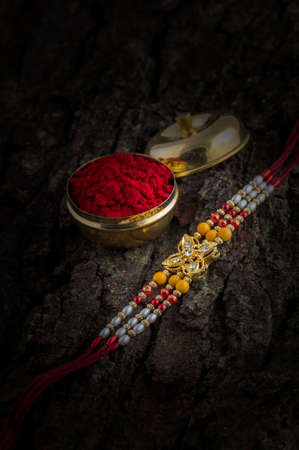 Indian festival: Raksha Bandhan background with an elegant Rakhi, Rice Grains and Kumkum. A traditional Indian wrist band which is a symbol of love between Brothers and Sisters.の写真素材