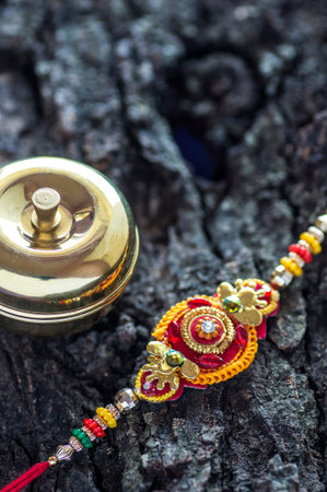 Indian festival: Raksha Bandhan background with an elegant Rakhi, Rice Grains and Kumkum. A...