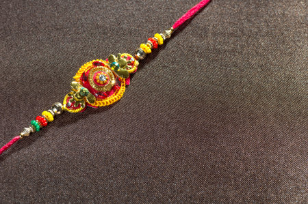 Raksha Bandhan background with an elegant Rakhi. A traditional Indian wrist band