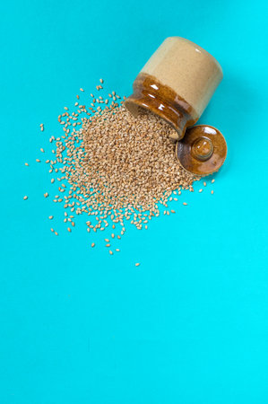 Sesame Seeds in pot on blue background