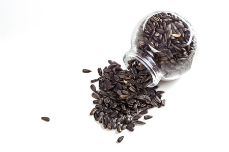 Sunflower Seeds in glass pot on white background. Helianthus annuus.