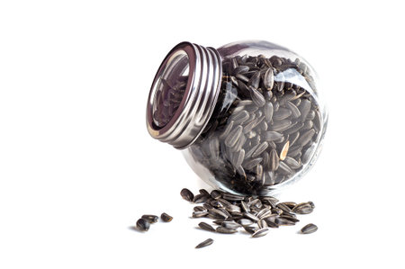 Sunflower Seeds in glass pot on white background. Helianthus annuus.