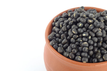 Urad dal, black gram, Vigna mungo in clay pot on white background