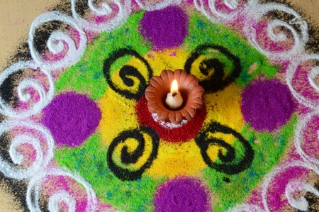 Clay diya lamps lit during diwali celebration, Rangoli in backgroundの写真素材