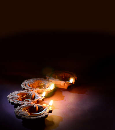 Colorful clay Diya (Lantern) lamps lit during Diwali celebration. Greetings Card Design Indian Hindu Light Festival called Diwali.の写真素材