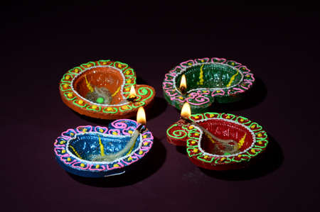 Colorful clay Diya (Lantern) lamps lit during Diwali celebration. Greetings Card Design Indian Hindu Light Festival called Diwali.の写真素材