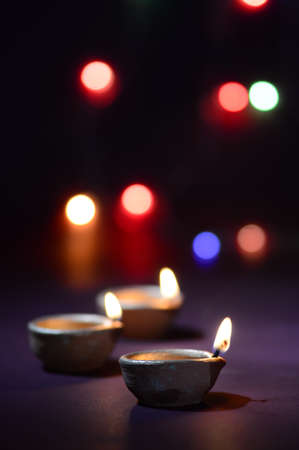 Colorful clay Diya (Lantern) lamps lit during Diwali celebration. Greetings Card Design Indian Hindu Light Festival called Diwali.の写真素材