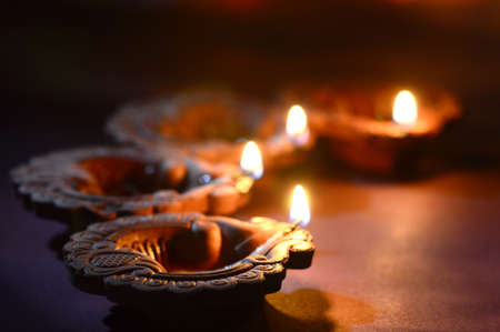 Clay diya lamps lit during Diwali Celebration. Greetings Card Design Indian Hindu Light Festival called Diwaliの写真素材