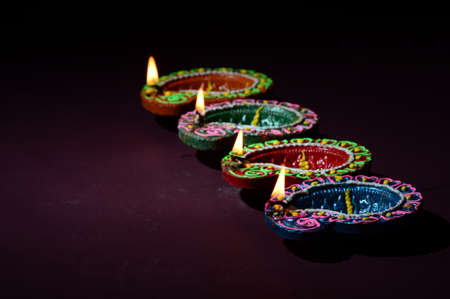 Colorful clay Diya (Lantern) lamps lit during Diwali celebration. Greetings Card Design Indian Hindu Light Festival called Diwali.の写真素材