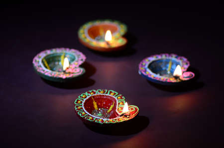 Colorful clay Diya (Lantern) lamps lit during Diwali celebration. Greetings Card Design Indian Hindu Light Festival called Diwali.の写真素材