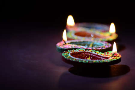 Colorful clay Diya (Lantern) lamps lit during Diwali celebration. Greetings Card Design Indian Hindu Light Festival called Diwali.の写真素材