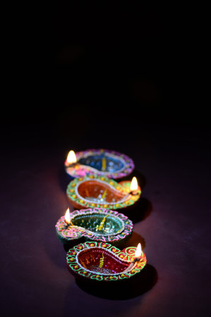 Colorful clay Diya (Lantern) lamps lit during Diwali celebration. Greetings Card Design Indian Hindu...