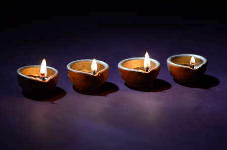 Colorful clay Diya (Lantern) lamps lit during Diwali celebration. Greetings Card Design Indian Hindu Light Festival called Diwali.の写真素材