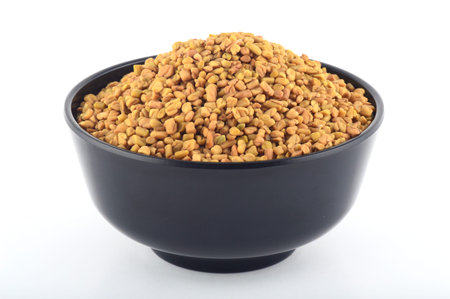 Fenugreek seeds in bowl isolated on white backgroundの写真素材