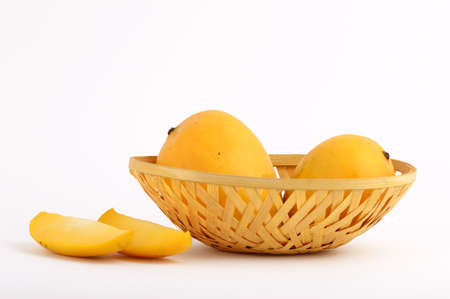 Mango fruit in basket with slice on white backgroundの写真素材