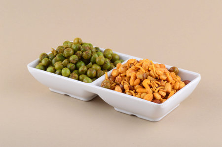 Indian snack: Mixture and Spiced fried green peas {chatpata matar} in white plate.の写真素材