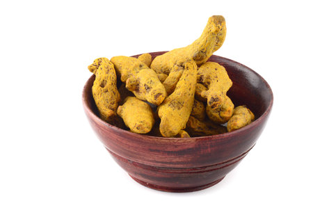 Dry Turmeric roots or barks in wooden bowl isolated on white backgroundの写真素材