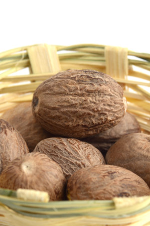 Nutmeg in bamboo basket isolated on white backgroundの写真素材