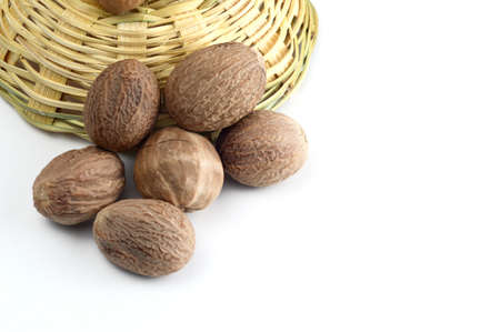 Nutmeg in bamboo basket isolated on white backgroundの写真素材