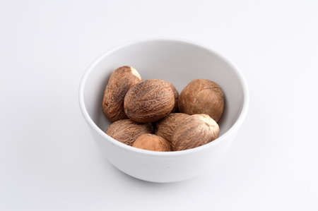 Nutmeg in white plate isolated on white backgroundの写真素材