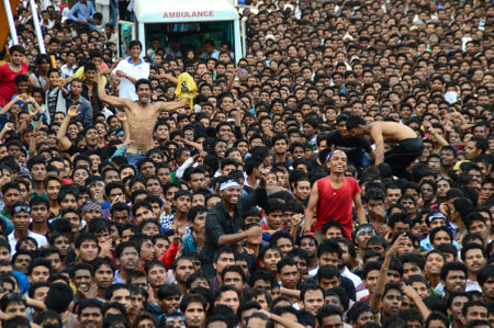 AMRAVATI, MAHARASHTRA, INDIA - AUGUST 24 : Crowd of young People enjoying "Govinda" at Dahi Handi festival to celebrate God Krishna's Birth in Amravati, Maharashtra, India. 24 August 2014のeditorial素材