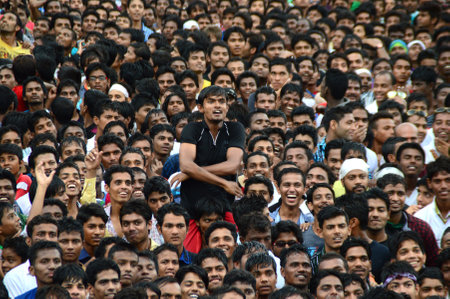 AMRAVATI, MAHARASHTRA, INDIA - AUGUST 24 : Crowd of young People enjoying Govinda at Dahi Handi festival to celebrate God Krishna's Birth in Amravati, Maharashtra, India. 24 August 2014