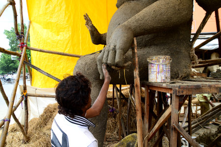 NAGPUR, MAHARASHTRA - 3 AUGUST 2014 : Artist gives finishing touches on an idol of the Hindu god Lord Ganesha at an artist's workshop for Ganesha-festival, 3 August 2014, Maharashtra, India.のeditorial素材