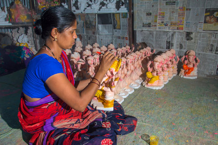 AMRAVATI, MAHARASHTRA - 26 AUGUST 2016 : Artist gives finishing touches on an idol of the Hindu god Lord Ganesha at an artist's workshop for Ganesha-festival, 26 August 2016, Maharashtra, India.のeditorial素材