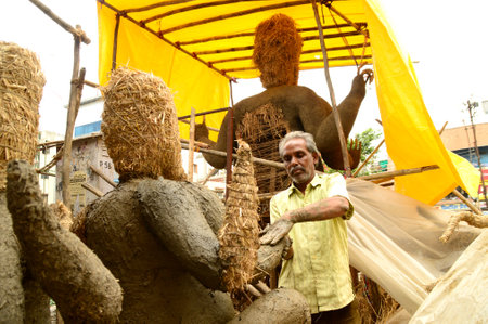 NAGPUR, MAHARASHTRA - 3 AUGUST 2014 : Artist gives finishing touches on an idol of the Hindu god Lord Ganesha at an artist's workshop for Ganesha-festival, 3 August 2014, Maharashtra, India.のeditorial素材