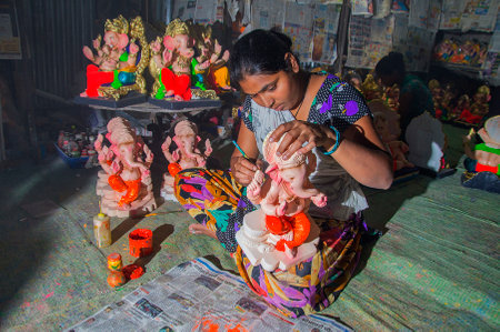 AMRAVATI, MAHARASHTRA - 26 AUGUST 2016 : Artist gives finishing touches on an idol of the Hindu god Lord Ganesha at an artist's workshop for Ganesha-festival, 26 August 2016, Maharashtra, India.のeditorial素材
