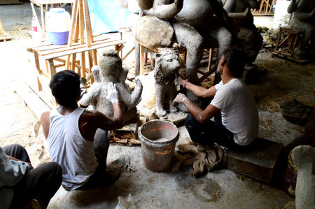 NAGPUR, MAHARASHTRA - 3 AUGUST 2014 : Artist gives finishing touches on an idol of the Hindu god Lord Ganesha at an artist's workshop for Ganesha-festival, 3 August 2014, Maharashtra, India.のeditorial素材