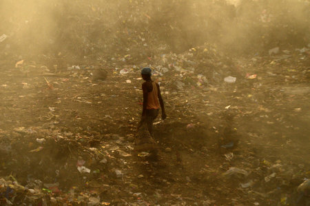 AMRAVATI, MAHARASHTRA, INDIA - APRIL 09, 2014: Unidentified rag pickers search for recyclable material in the garbage. Land and air pollution in India on April 09, 2014, Amravati, India.のeditorial素材