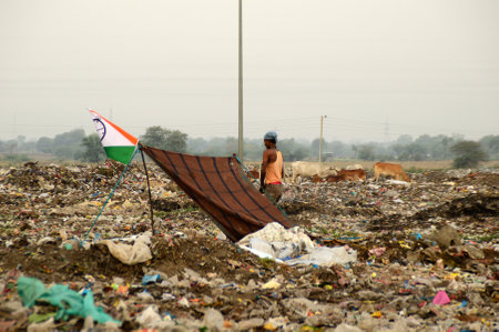 AMRAVATI, MAHARASHTRA, INDIA - APRIL 09, 2014: Unidentified rag pickers search for recyclable material in the garbage. Land and air pollution in India on April 09, 2014, Amravati, India.のeditorial素材