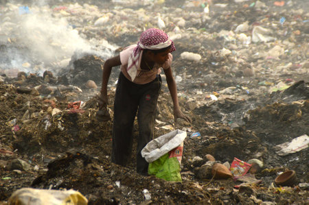 AMRAVATI, MAHARASHTRA, INDIA - APRIL 09, 2014: Unidentified rag pickers search for recyclable material in the garbage. Land and air pollution in India on April 09, 2014, Amravati, India.のeditorial素材