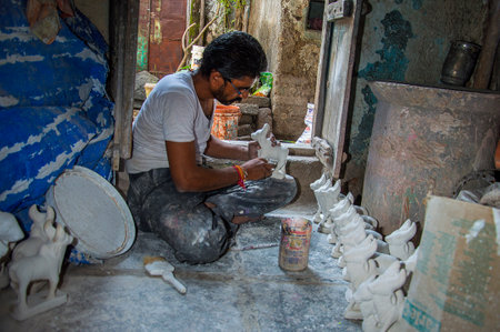 AMRAVATI, MAHARASHTRA - AUGUST 25, 2016: Artist gives finishing touches on statue of Bull at an artist's workshop for Bail (Bull) Pola Festival.のeditorial素材