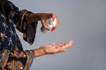 Portrait of young girl using or showing a sanitizing gel from a bottle for hands cleaning.