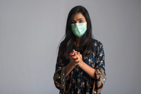 Portrait of young girl using or showing a sanitizing gel from a bottle for hands cleaning.