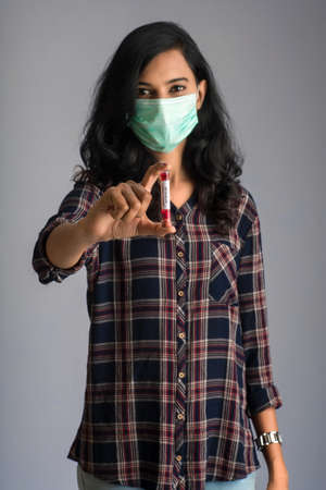 Woman holding a test tube with blood sample for coronavirus or 2019-nCoV analyzing.の写真素材