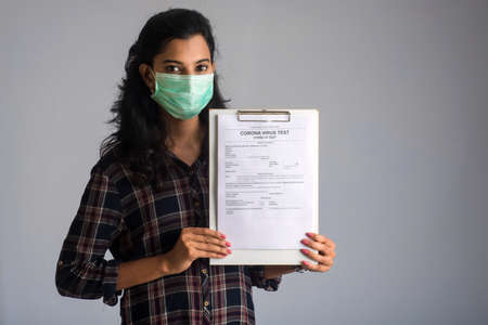 Coronavirus concept for a blood test. A young girl reading or filling a medical test form for coronavirus testing.の写真素材