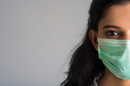 Closeup portrait of a young girl or woman doctor wearing a medical or surgical mask