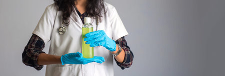Portrait of woman doctor showing a bottle of sanitizing gel for hands cleaning.
