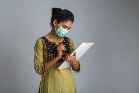 Coronavirus concept for a blood test. A young girl reading or filling a medical test form for coronavirus testing.の写真素材
